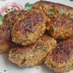 Leckere türkische Hackröllchen serviert mit Gurkenjoghurt und Salat