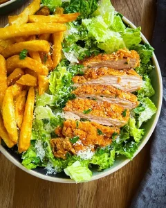 Frisch angerichtete Caesar Salad Bowl mit Dressing und Parmesan