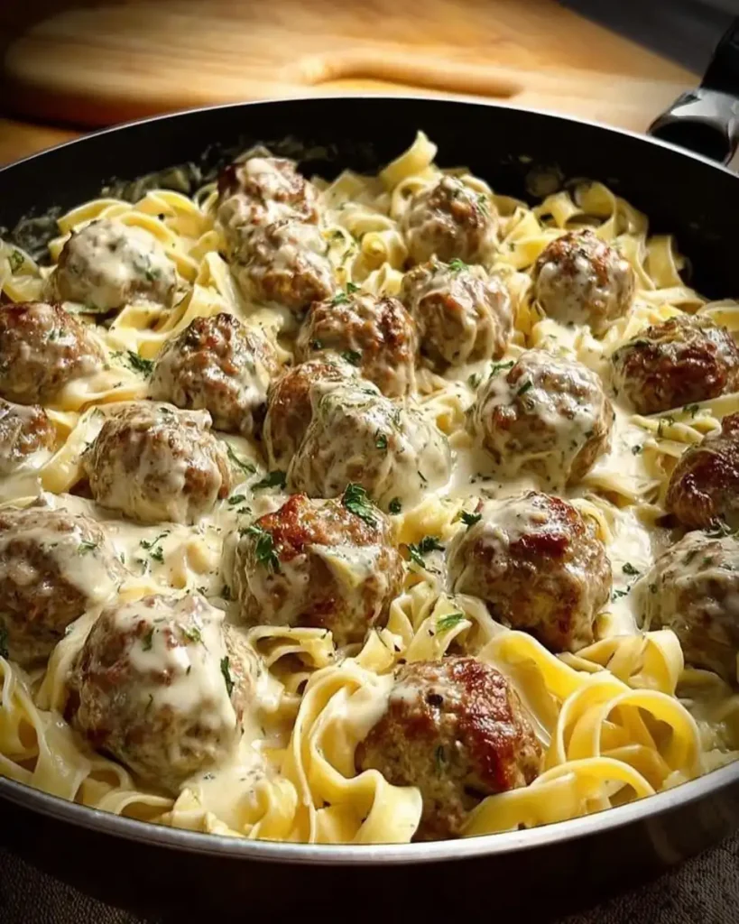 Eine Portion Fleischbällchen mit Nudeln und Sahnesoße auf einem Teller