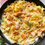 Nahaufnahme von Pasta-Nudeln in einer hellen Frischkäse-Sauce mit Lachs