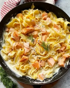 Nahaufnahme von Pasta-Nudeln in einer hellen Frischkäse-Sauce mit Lachs