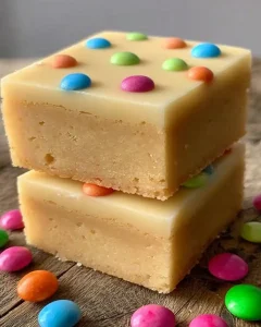 Aufgeschnittene weiße Schokoladen-Brownies mit Glasur und bunten Streuseln